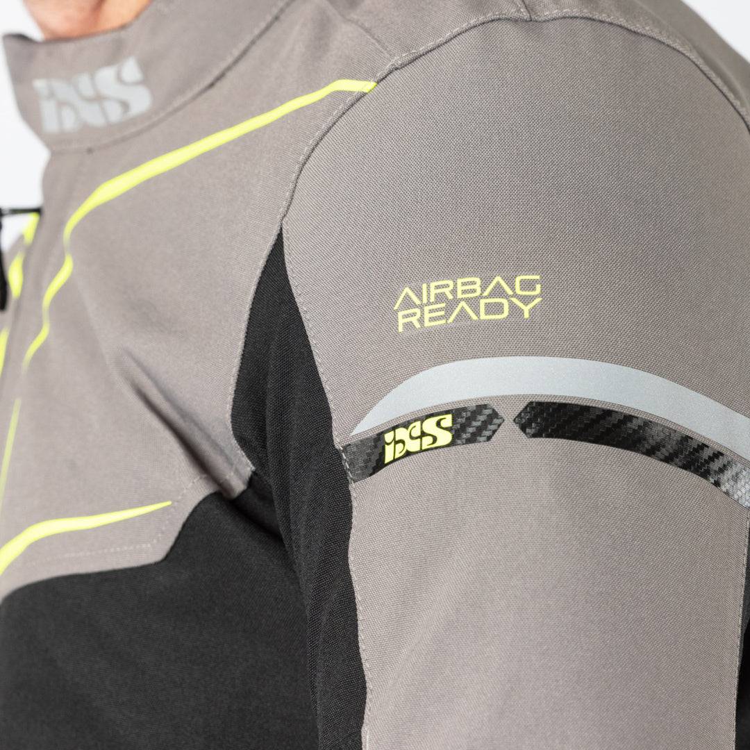 Schwarze, graue und gelb-fluoreszierende iXS Sport Jacke TS-Pro ST+ für Touring, aus robustem Textil mit reflektierenden Elementen.
