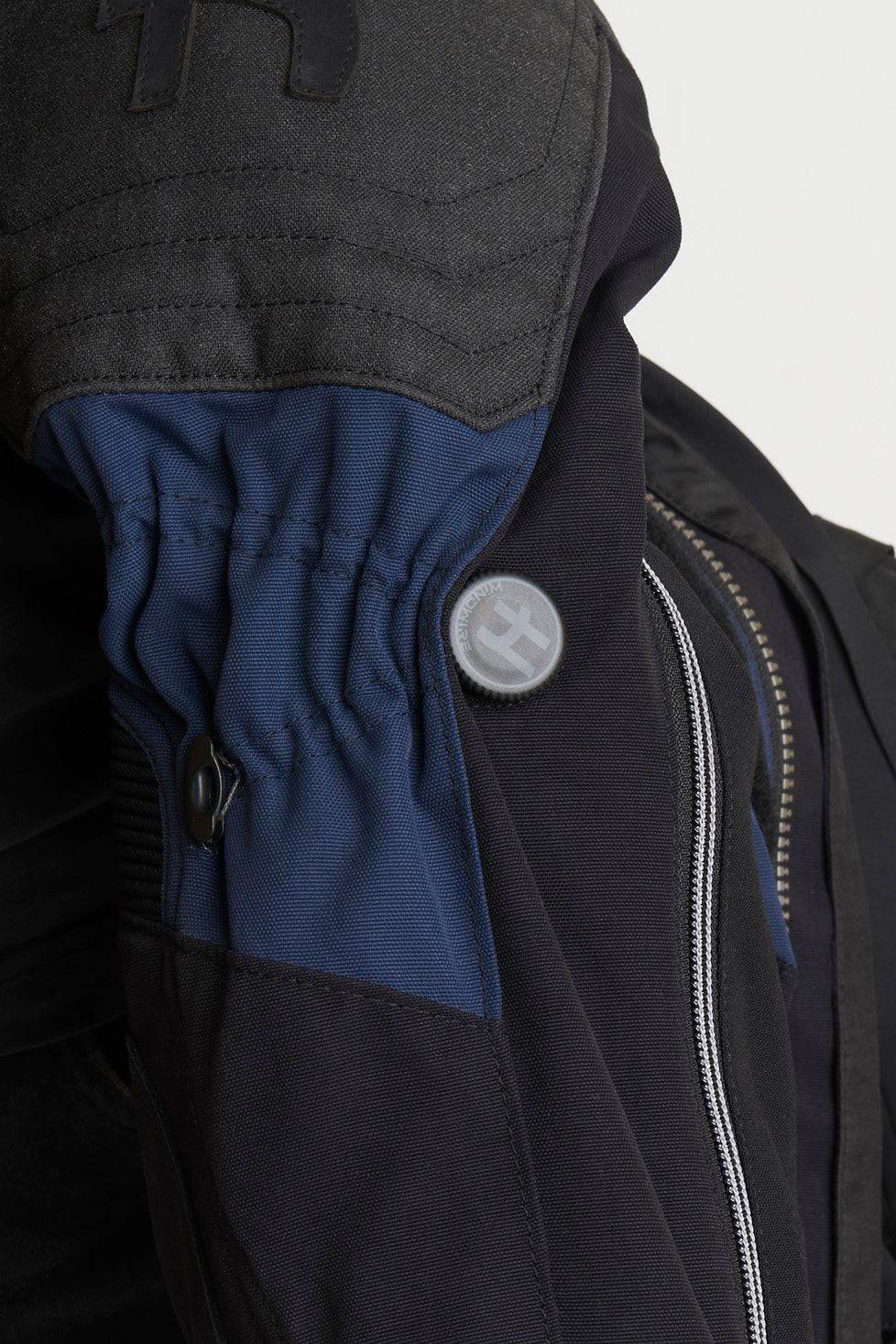 Schwarze und blaue Halvarssons Motorradjacke Mora für Abenteuer, sichtbare Details und robuste Textur, Front-Reißverschluss.