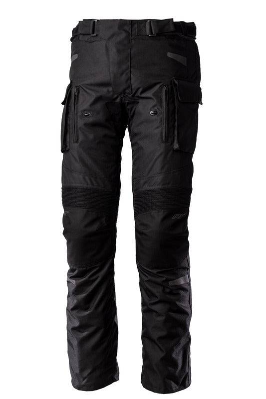 Schwarze RST Endurance CE Textil-Motorradhose für Adventure, strapazierfähig mit Protektoren, auf einem Motorrad-Sitz liegend.