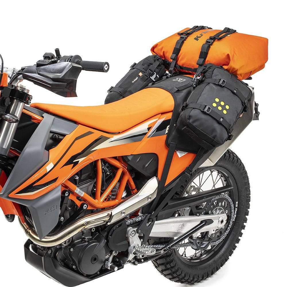 Oranger Kriega Rollpack-20, robustes Rollpack für Motorräder, mit verstellbaren Gurten und mehreren Fächern, auf einer Fahrt montiert.