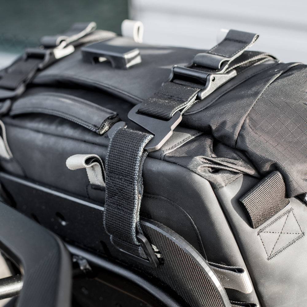 Kriega OS-32 Gepäcktasche aus robustem Material, seitliche Ansicht mit Befestigungssystem und reflektierenden Elementen.