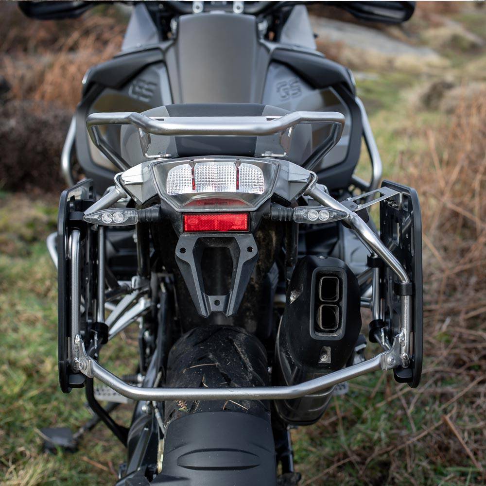 Kriega OS-Halteplatten-Adapter für BMW GS, Montagekit-Taschen, zeigt die schwarzen Halteplatten und Montageschrauben auf weißem Hintergrund.