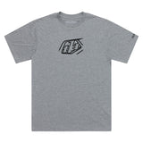 Graues TROY LEE DESIGNS Badge T-Shirt aus Freizeitbekleidung mit Logo-Print, bequemes Meliert-Design, vorne sichtbar.