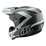 Motocrosshelm von TROY LEE DESIGNS in Grau und Weiß mit aerodynamischem Design und visier für Offroad-Fahrten.