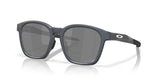 OAKLEY Shackle Sonnenbrille in Blau mit Steel-Frame und schwarzen Prizm-Gläsern, modelliert auf einem weißen Hintergrund