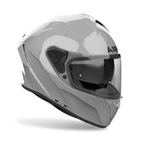 Airoh Spark 2 Integralhelm in Zement Grau, mit klarem Visier und aerodynamischem Design, auf einem Motorrad liegend