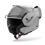 Airoh Mathisse II Klapphelm in Zement Grau, mit klappbarem Visier und aerodynamischem Design, auf einem schwarzen Hintergrund.