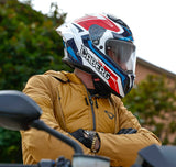 Weiß-rot-blauer Caberg Drift Evo II Jarama Integralhelm mit aerodynamischem Design und Visier, auf einem neutralen Hintergrund.