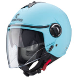 Mann trägt die matte, hellblaue Jethelm Riviera V4 X von Caberg, mit klarem Visier und aerodynamischem Design.