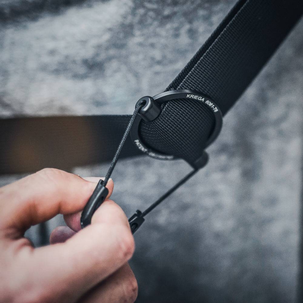 Schwarze Kriega Umhängetasche Sling aus strapazierfähigem Material mit verstellbarem Schultergurt und mehreren Fächern.